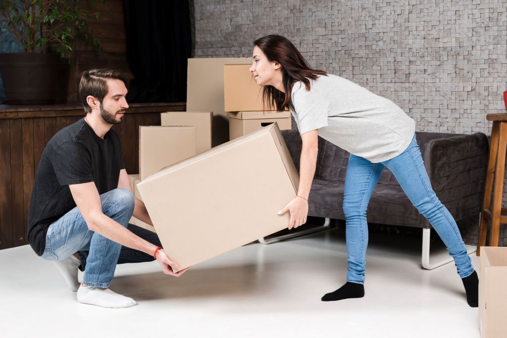 man and woman carrying cardboard boxes